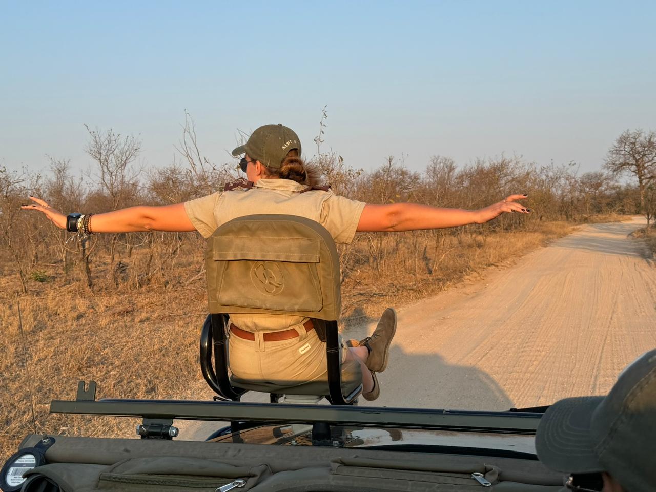 A guide sits on the tracker seat of a game viewing vehicle. A guide sits on the tracker seat of a game viewing vehicle.