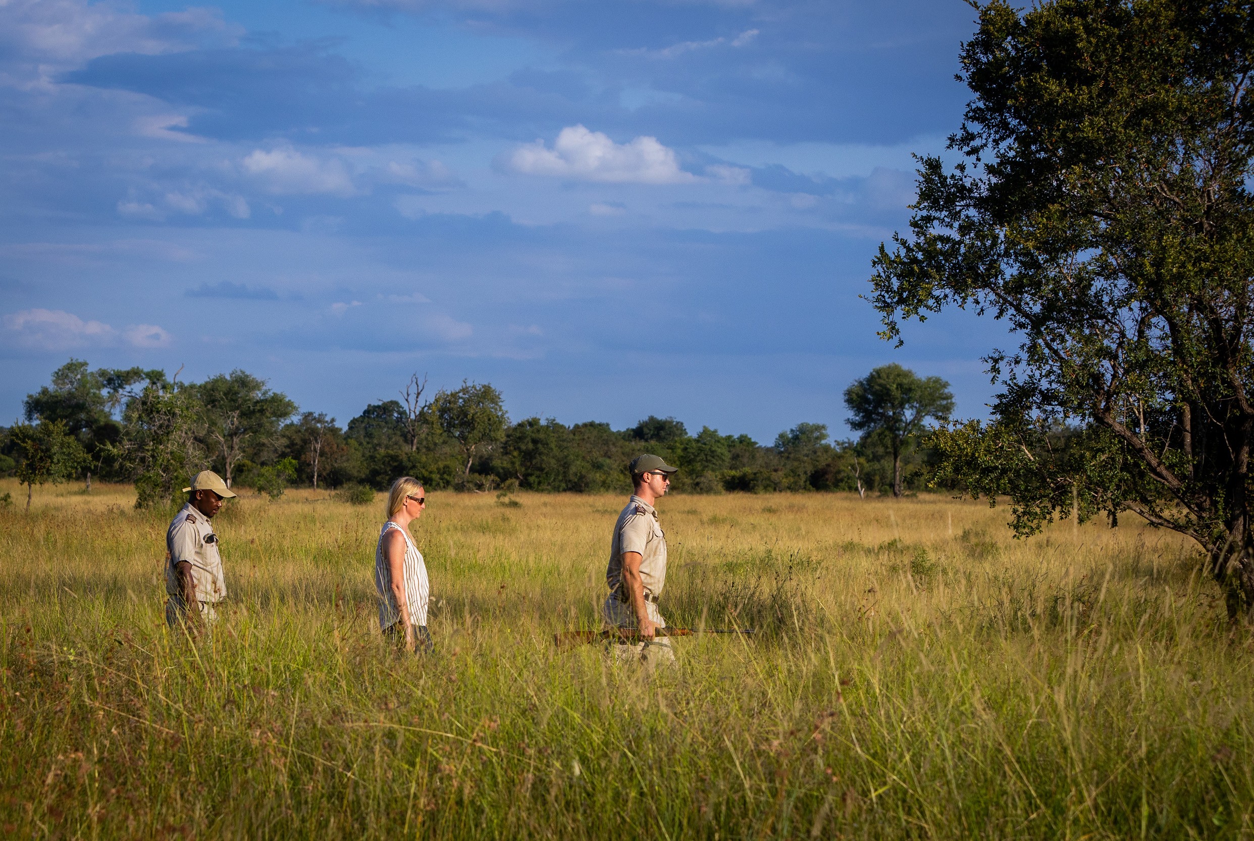 A guest walks between two Sabi Sabi guides on a walking safari