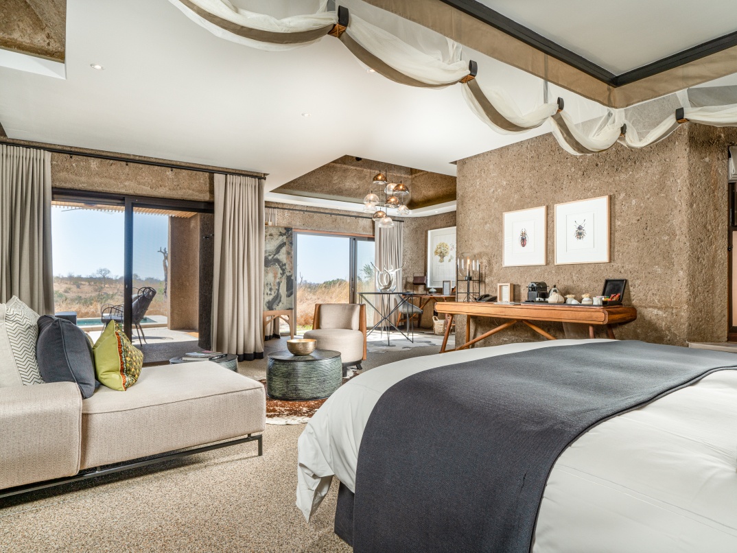 Experience the seamless integration of a spacious bedroom with the natural surroundings in Earth Lodge's Luxury Suite.