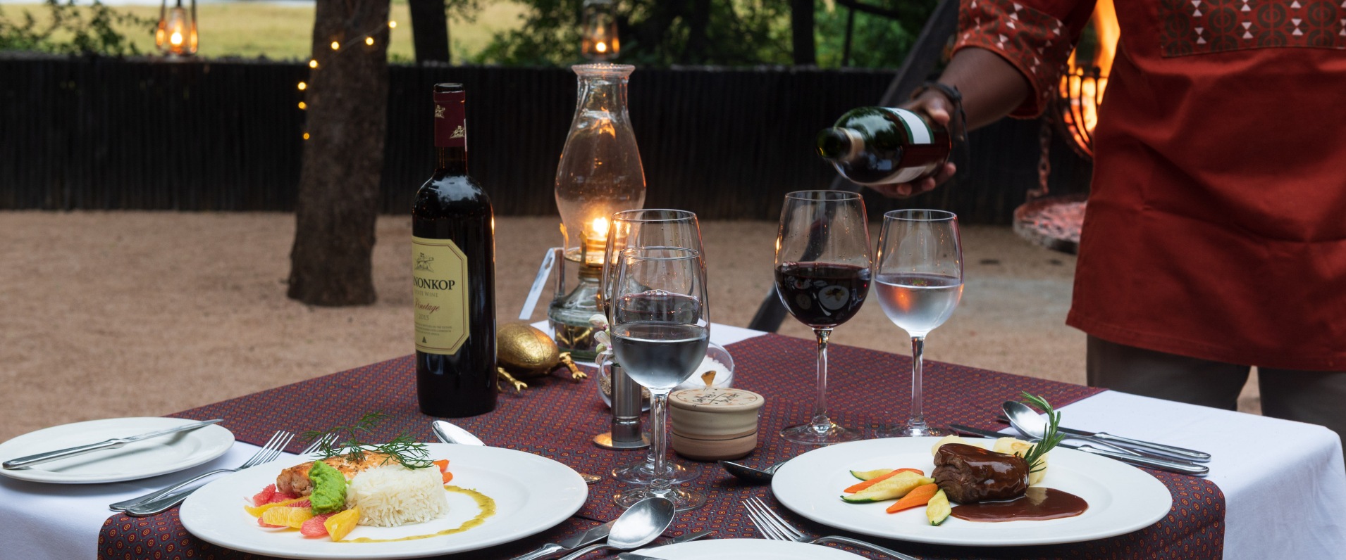Indulge in exquisite dining experiences under the starlit sky at Selati Camp's elegant outdoor boma.