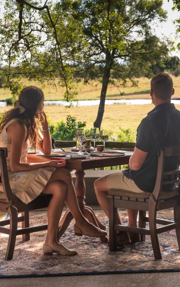 Sabi Sabi guests enjoying stunning views from the elevated deck at Sabi Sabi while savoring refreshments.