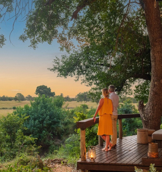Sabi Sabi guests savoring sunset hues from their secluded wooden deck.