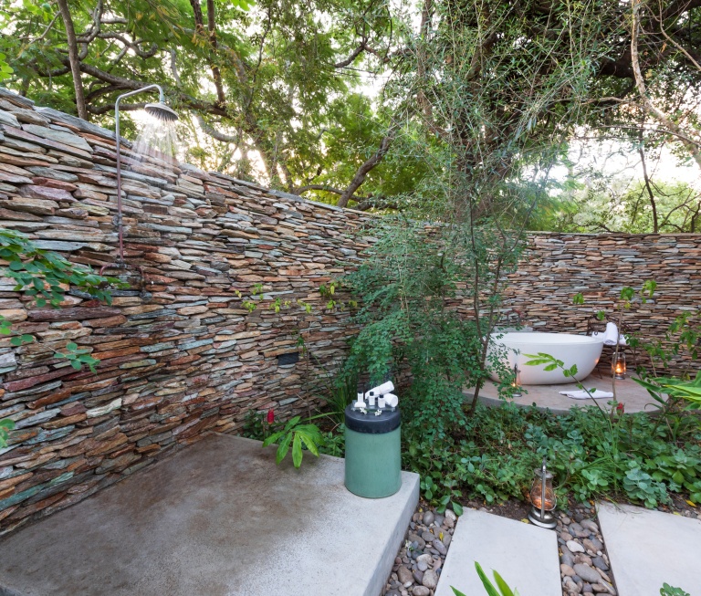 Selati Camp Luxury Suite open-air shower framed by majestic trees. Selati Camp Luxury Suite open-air shower framed by majestic trees.