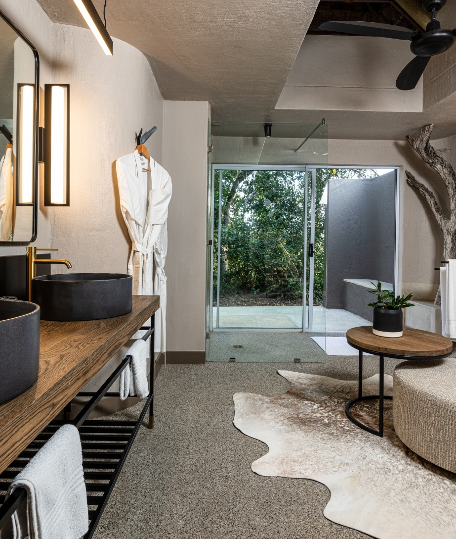 Enjoy an inviting en-suite bathroom and breathtaking views of the bushveld at Sabi Sabi Bush Lodge.