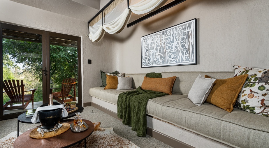The lounge area of your Sabi Sabi Bush Lodge Suite seamlessly connects with a private patio.